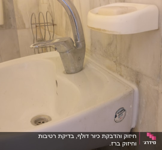 כיור עם ברז מתכת בחדר אמבטיה